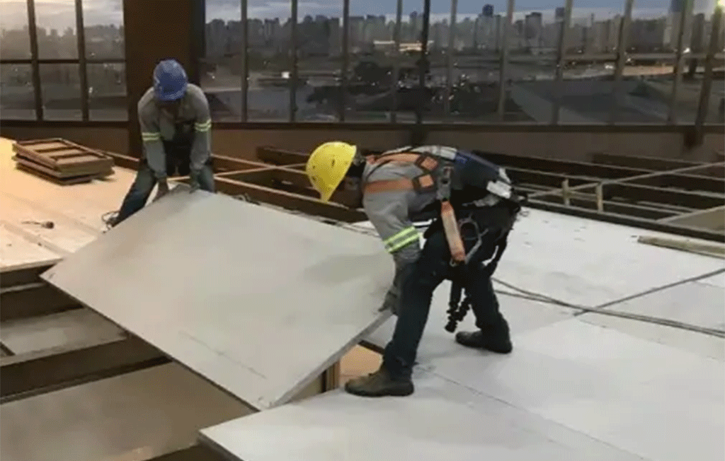 Dois homens instalando uma placa wall em um mezanino